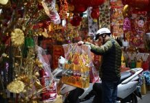 Người dân mua những vật phẩm truyền thống đồ cúng để cúng tiễn ông Công ông Táo về chầu trời. (Nguồn: TTXVN)