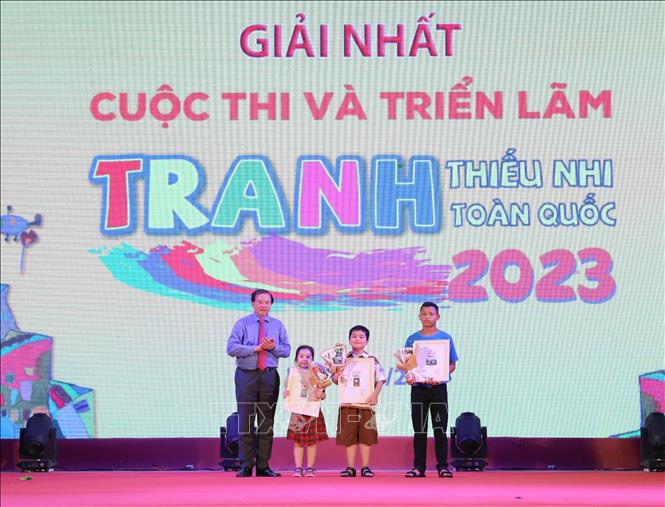 Thứ trưởng Bộ Văn hóa, Thể thao và Du lịch Tạ Quang Đông trao giải Nhất cho các em đạt giải ở Cuộc thi và Triển lãm tranh thiếu nhi toàn quốc năm 2023. Ảnh: Thanh Tùng/TTXVN
