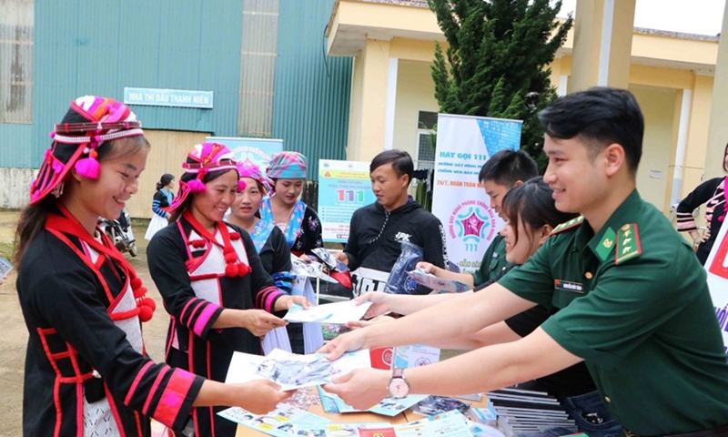 Bộ đội Biên phòng tỉnh Lai Châu phát tờ rơi tuyên truyền về phòng, chống mua bán người cho bà con xã Huổi Luông, huyện Phong Thổ. (Ảnh: Đức Duẩn)