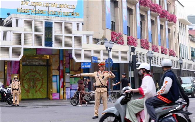 Cảnh sát giao thông điều tiết và phân luồng giao thông tại nút giao Tràng Tiền-Đinh Tiên Hoàng, Hà Nội vào sáng mùng 1 Tết. Ảnh: Phạm Kiên/TTXVN