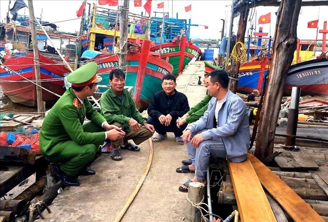 Công an xã Tiên Trang (Thanh Hóa) hướng dẫn ngư dân về công tác bầu cử. Ảnh: TTXVN phát