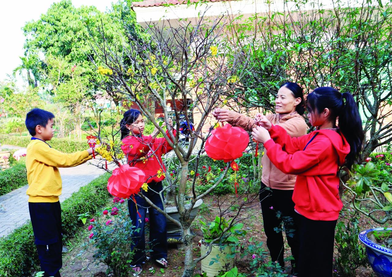 Các gia đình trong Làng trẻ em SOS Đồng Hới trang trí sân vườn để đón Tết - Ảnh: H.N